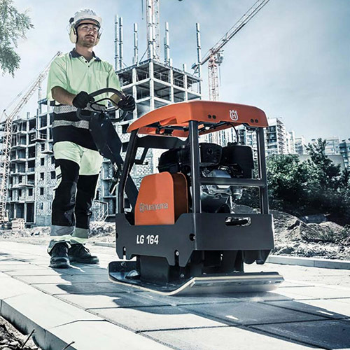 construction man using a plate compactor
